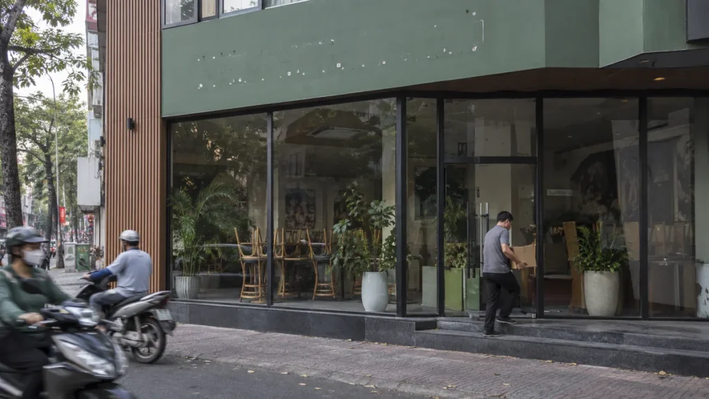 ベトナムで営業を終えたカフェ店舗から備品を運び出す作業員