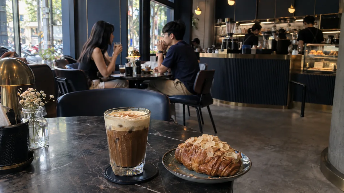 ホーチミンのモダンカフェに置かれた塩コーヒーとアーモンドクロワッサン