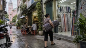 タンディン教会の裏路地で布地を運ぶ店主と街角の喫茶風景