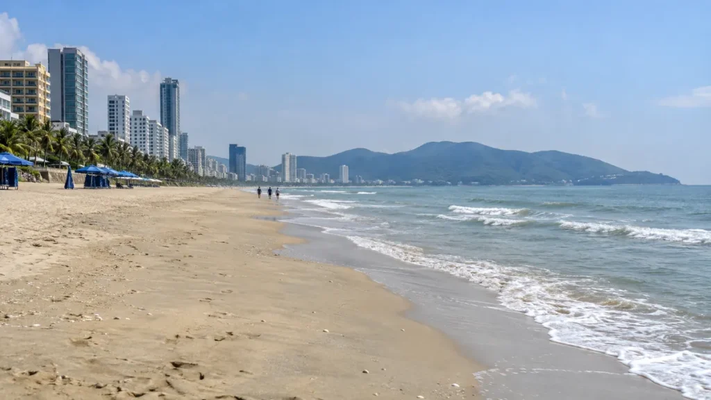 ダナンの街、砂浜、ソンチャ半島の自然が近接する関係を表したイメージ。ミーケーの海岸から北を望む構図で、実際の2026年連休の人出や個々の建物を再現した写真ではありません。
